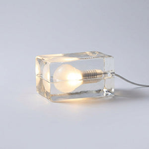 Bordlampe i form av en klar glassblokk med pære inni, Klar