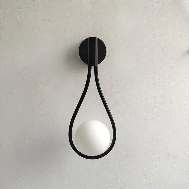 Vegglampe med frostet glasskule og dråpeformet metallramme