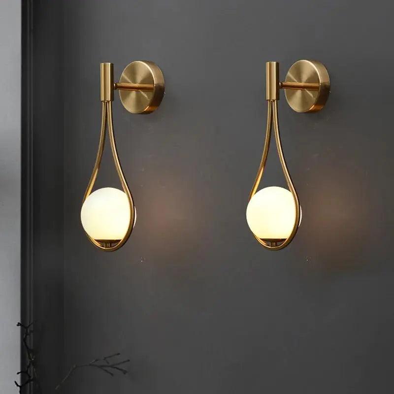 Vegglampe med frostet glasskule og dråpeformet metallramme