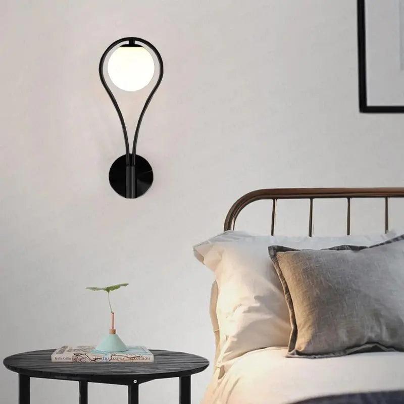 Vegglampe med frostet glasskule og dråpeformet metallramme