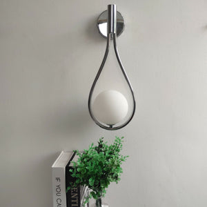 Vegglampe med frostet glasskule og dråpeformet metallramme
