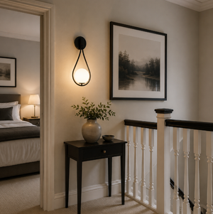 Vegglampe med frostet glasskule og dråpeformet metallramme