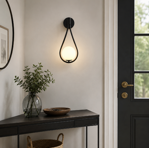 Vegglampe med frostet glasskule og dråpeformet metallramme