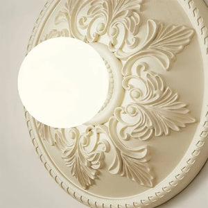 Rund vegglampe med ornamentert ramme og opalglass, Kremhvit