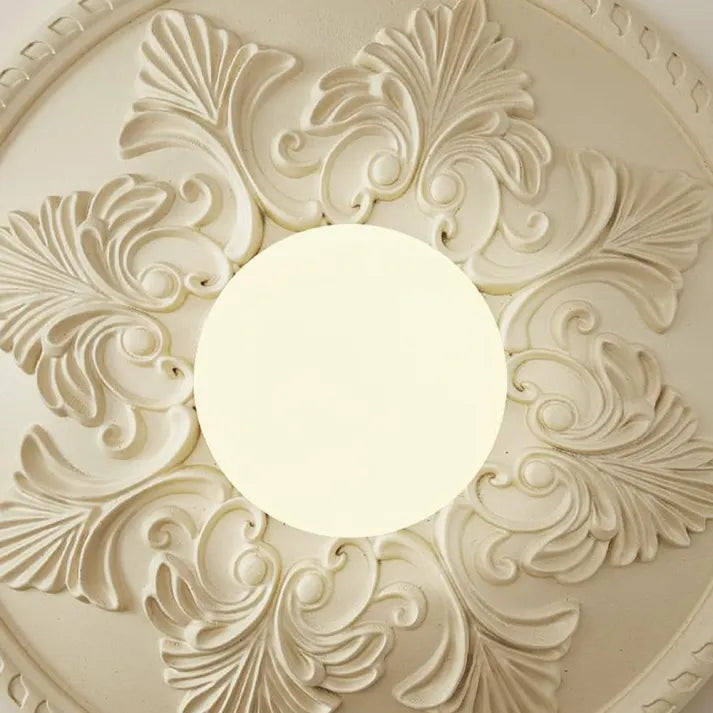 Rund vegglampe med ornamentert ramme og opalglass, Kremhvit